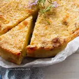 Delizioso gateau di patate dorato e croccante, guarnito con rosmarino fresco. Perfetto per ogni occasione.