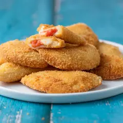 Sofficini fatti in casa dorati e croccanti, ripieni di pomodoro e mozzarella filante, pronti per essere gustati.