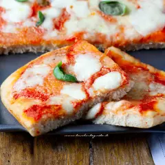 Deliziosa pizza senza glutine, con pomodoro filante e basilico fresco, pronta per essere gustata.