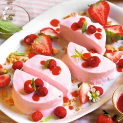 Delizioso semifreddo alle fragole, guarnito con fragoline di bosco, salsa rossa e foglioline verdi. Un dolce estivo perfetto.