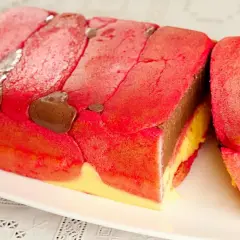 Zuppa inglese ricetta originale emiliana: strati di pan di Spagna rosso e giallo, crema al cioccolato e liquore, decorata con savoiardi.
