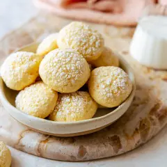 Biscotti da inzuppo soffici e dorati, cosparsi di zucchero a velo, pronti per essere gustati con un bicchiere di latte.