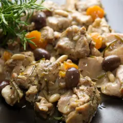 Coniglio alla ligure con olive, pinoli e rosmarino, un piatto saporito e profumato.