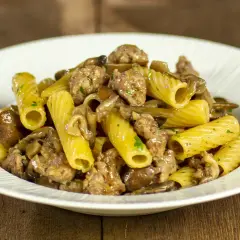 Piatto di pasta con funghi e salsiccia, un classico saporito.