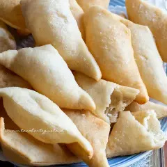 Un piatto colmo di gnocco fritto, dorato e croccante, pronto per essere gustato. La ricetta perfetta per un aperitivo sfizioso.