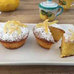 Deliziosi muffin caprese al limone, spolverati di zucchero a velo e decorati con scorzette candite.