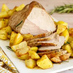 Succulento arrosto di vitello al forno, affettato e servito con patate arrosto dorate e profumate al rosmarino.