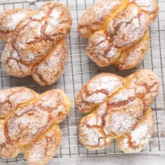 Colomba pasquale facile e veloce, dorata e cosparsa di zucchero a velo, raffreddata su una griglia.