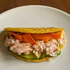 Piadina di ceci ripiena di tacchino sfilacciato, zucchine e carote a julienne. Un pasto leggero e gustoso.