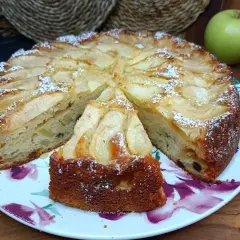 Una fetta di torta di mele soffice e profumata, cosparsa di zucchero a velo, pronta per essere gustata.