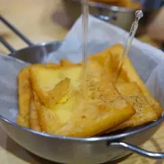 Un cestino di pane e panelle dorate, croccanti e appena fritte, pronte per essere gustate.