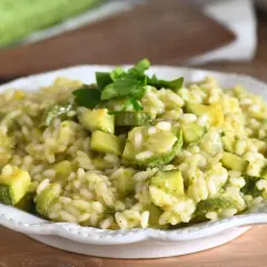 Un cremoso risotto con zucchine, guarnito con prezzemolo fresco, pronto per essere gustato.