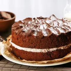 Torta al cioccolato a due strati, con glassa e zucchero a velo, che ricorda una torta Kinder Delice fatta in casa.