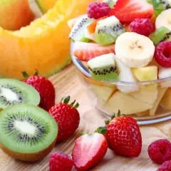 Una fresca macedonia di frutta, con fragole, kiwi, banane e melone, pronta per essere gustata.