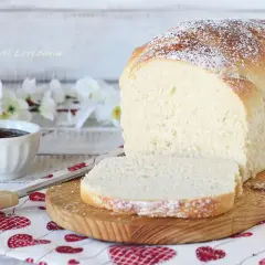 Un soffice pan brioche dolce, spolverato di zucchero a velo, pronto per essere gustato con marmellata.