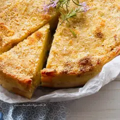 Delizioso gateau di patate dorato e croccante, guarnito con rosmarino fresco. Perfetto per ogni occasione.