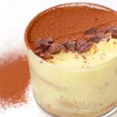 Un bicchiere di tiramisù, con cacao e scaglie di cioccolato. Perfetto per scoprire come si fa il tiramisù.