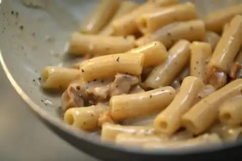 Primo piatto di pasta alla gricia, con rigatoni cremosi e guanciale croccante.