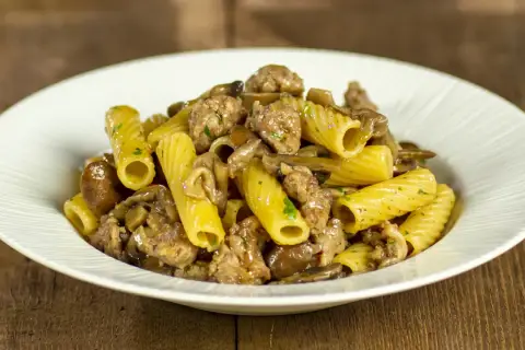 Piatto di pasta con funghi e salsiccia, un classico saporito.