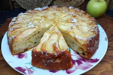 Una fetta di torta di mele soffice e profumata, cosparsa di zucchero a velo, pronta per essere gustata.
