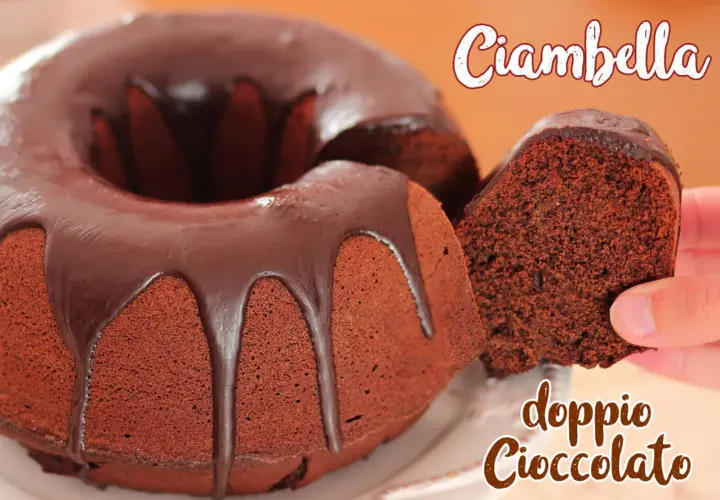 Ciambella al cioccolato, soffice e golosa, con una glassa lucida che cola. Una fetta viene sollevata, mostrando la sua consistenza.