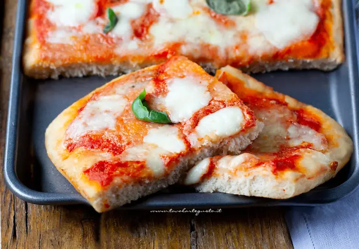 Deliziosa pizza senza glutine, con pomodoro filante e basilico fresco, pronta per essere gustata.