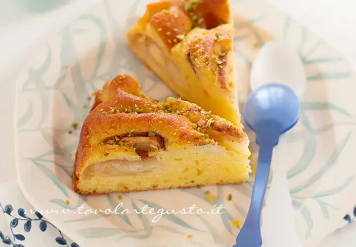 Fette di torta di mele senza burro, soffice e profumata, guarnita con pistacchi tritati.