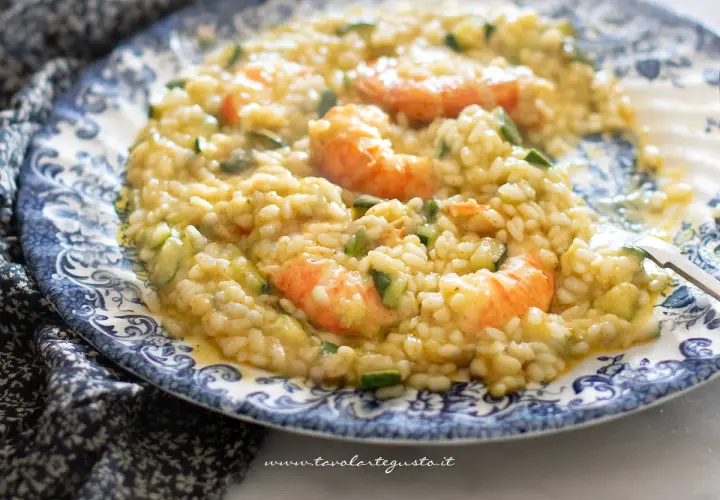 Risotto cremoso con zucchine e gamberetti, un piatto estivo da gustare.