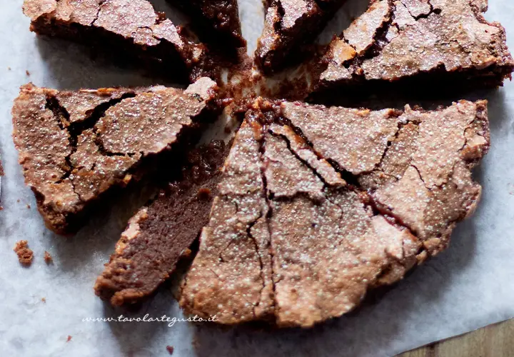Torta morbida al cioccolato, tagliata a spicchi, cosparsa di zucchero a velo, perfetta per celebrare la Pasqua con un tocco goloso.
