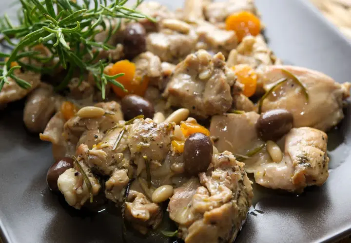 Coniglio alla ligure con olive, pinoli e rosmarino, un piatto saporito e profumato.
