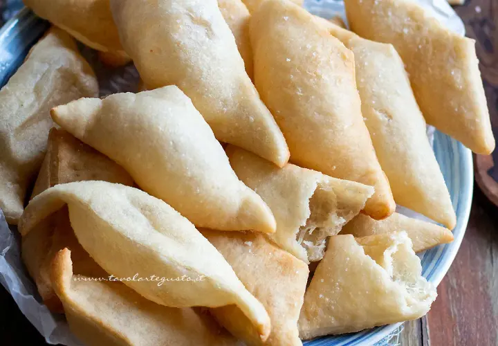 Un piatto colmo di gnocco fritto, dorato e croccante, pronto per essere gustato. La ricetta perfetta per un aperitivo sfizioso.