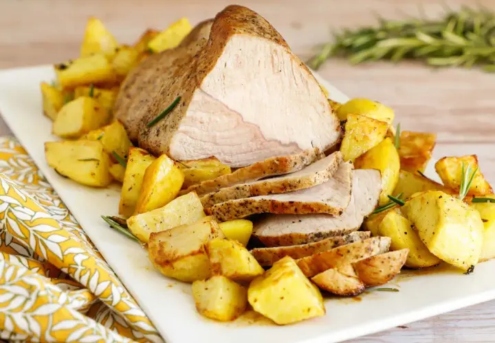 Succulento arrosto di vitello al forno, affettato e servito con patate arrosto dorate e profumate al rosmarino.