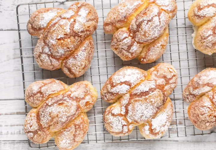 Colomba pasquale facile e veloce, dorata e cosparsa di zucchero a velo, raffreddata su una griglia.