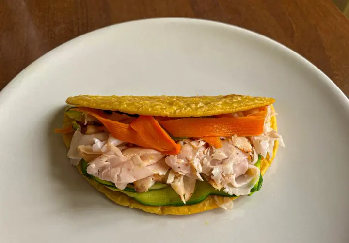 Piadina di ceci ripiena di tacchino sfilacciato, zucchine e carote a julienne. Un pasto leggero e gustoso.