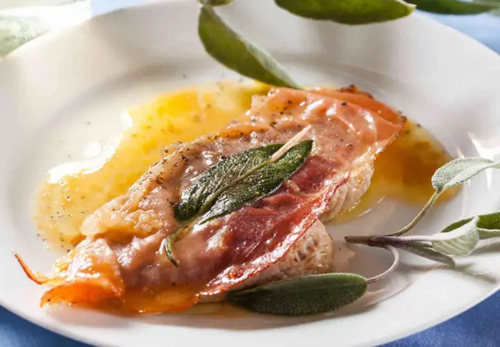 Saltimbocca alla romana ricetta: fettina di vitello con prosciutto crudo e salvia, bagnata da un sugo dorato.