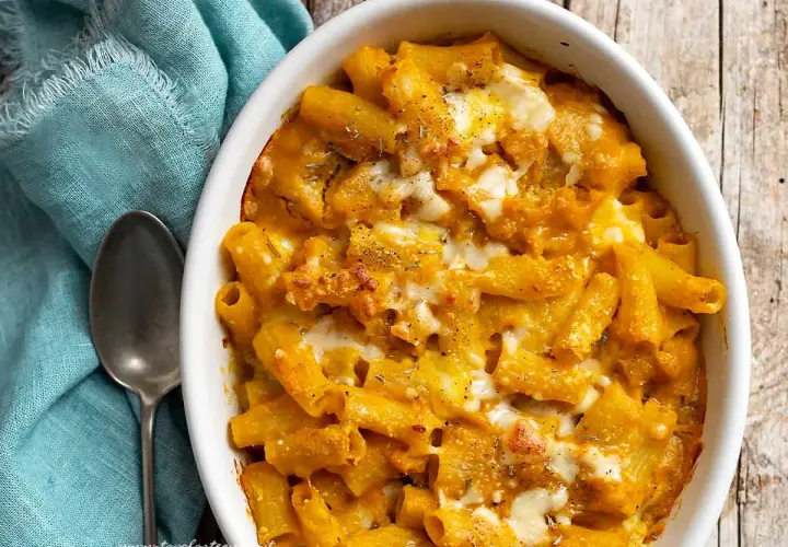 Piatto invitante di pasta con la zucca, gratinata al forno con formaggio filante e erbe aromatiche.