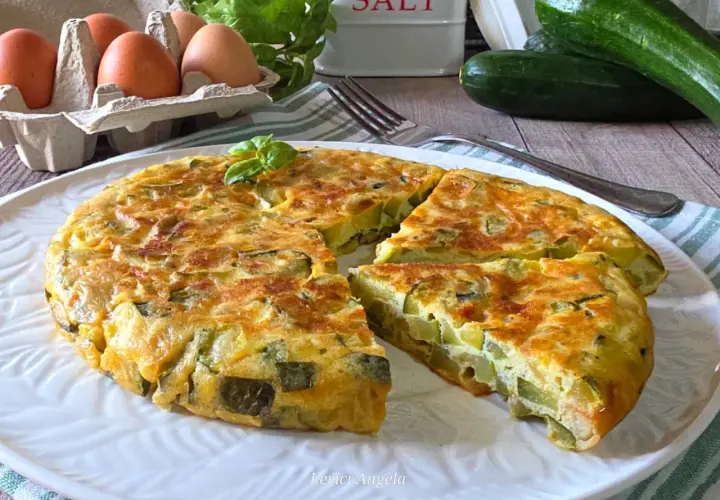 Una gustosa frittata di zucchine, dorata e soffice, con ingredienti freschi come uova e basilico.