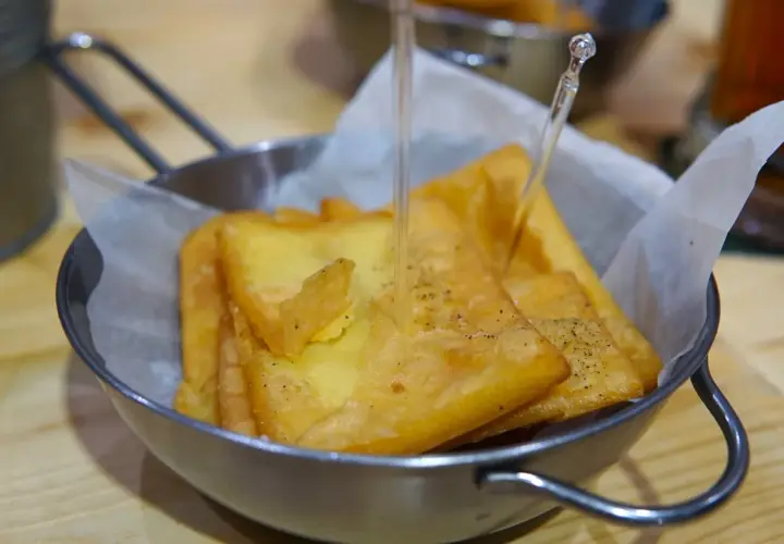 Un cestino di pane e panelle dorate, croccanti e appena fritte, pronte per essere gustate.