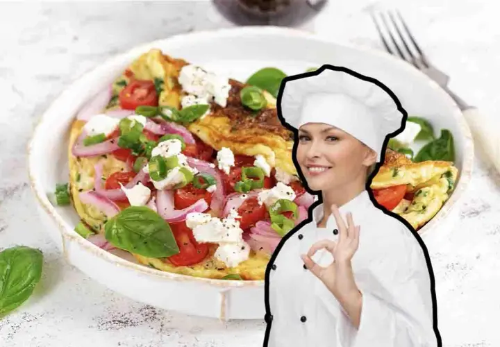 Chef sorridente mostra una deliziosa frittata di cipolle, pomodori e formaggio feta, guarnita con basilico fresco.