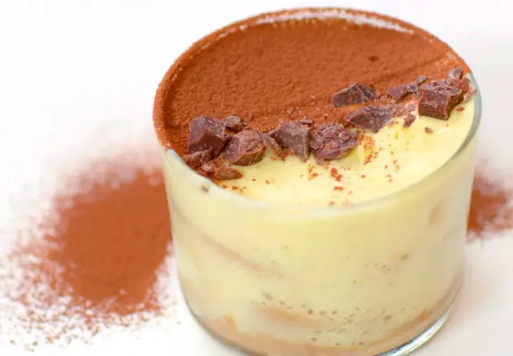 Un bicchiere di tiramisù, con cacao e scaglie di cioccolato. Perfetto per scoprire come si fa il tiramisù.
