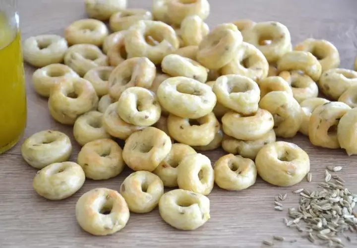 Taralli pugliesi ricetta originale: tanti piccoli anelli dorati, croccanti e profumati, pronti per essere gustati.