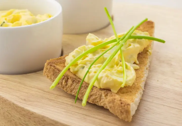 Fetta di pane tostato con salsa bolzanina ricetta, guarnita con erba cipollina. Cremosa e invitante, perfetta per un aperitivo.
