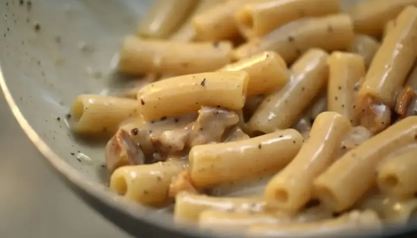 Primo piatto di pasta alla gricia, con rigatoni cremosi e guanciale croccante.