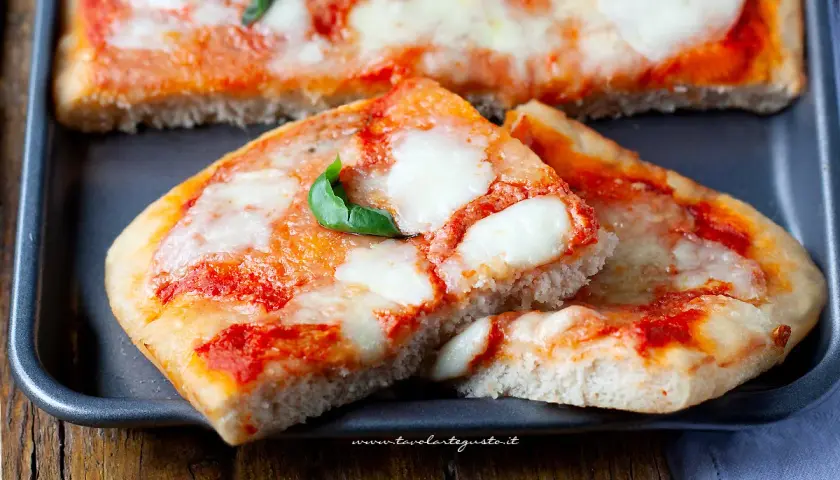 Deliziosa pizza senza glutine, con pomodoro filante e basilico fresco, pronta per essere gustata.
