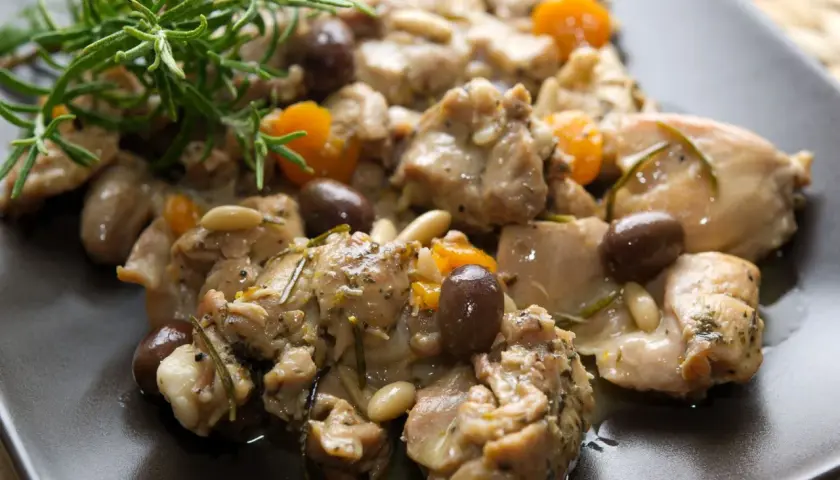 Coniglio alla ligure con olive, pinoli e rosmarino, un piatto saporito e profumato.