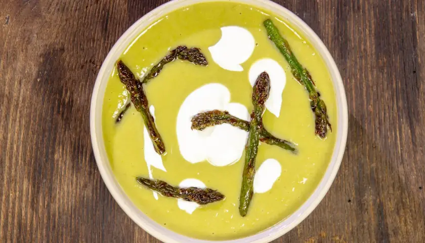 Crema di asparagi vellutata con asparagi arrostiti e un tocco di panna.