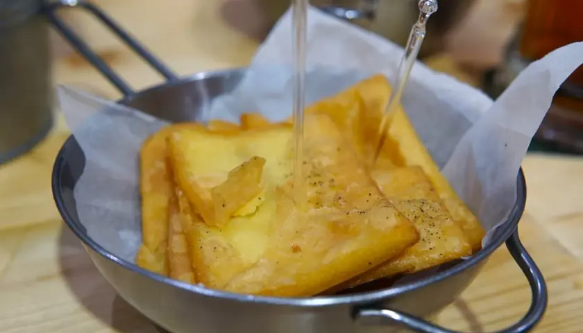 Un cestino di pane e panelle dorate, croccanti e appena fritte, pronte per essere gustate.