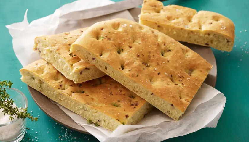 Focaccia con lievito istantaneo, soffice e dorata, condita con erbe aromatiche e sale grosso. Perfetta per un aperitivo veloce.