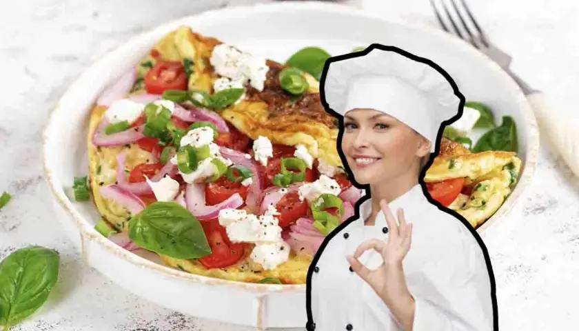 Chef sorridente mostra una deliziosa frittata di cipolle, pomodori e formaggio feta, guarnita con basilico fresco.