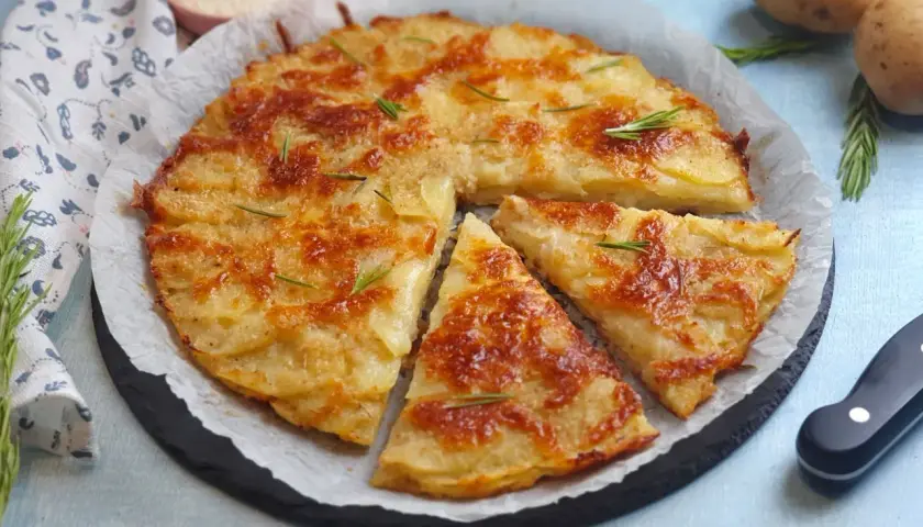 Una deliziosa torta di patate dorata e croccante, guarnita con rosmarino fresco. Perfetta per ogni occasione.